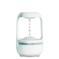 White anti-gravity humidifier with floating water droplet on a desk next to a USB cable