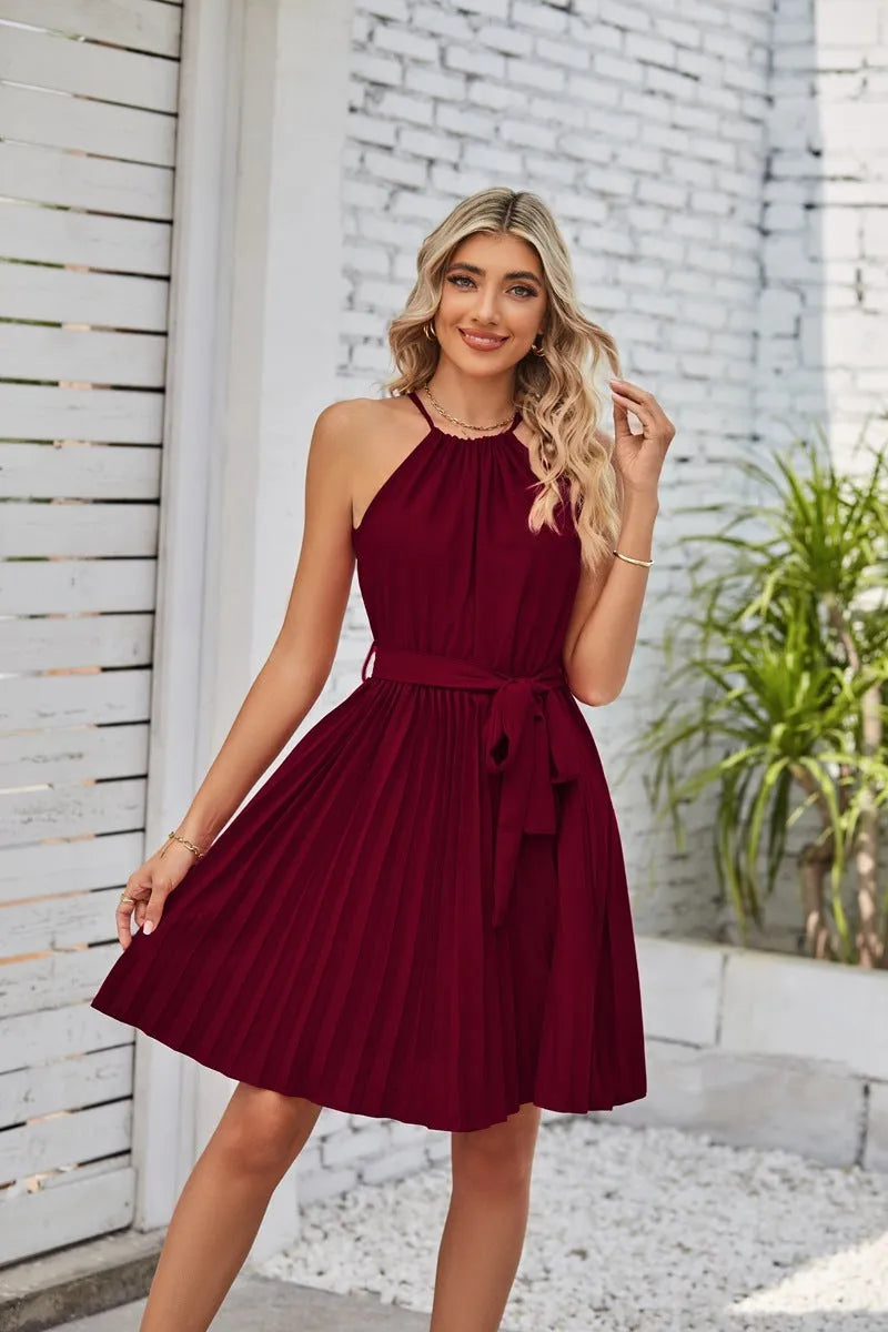 Women's black halter neck strapless sundress with a pleated midi skirt and waist tie
