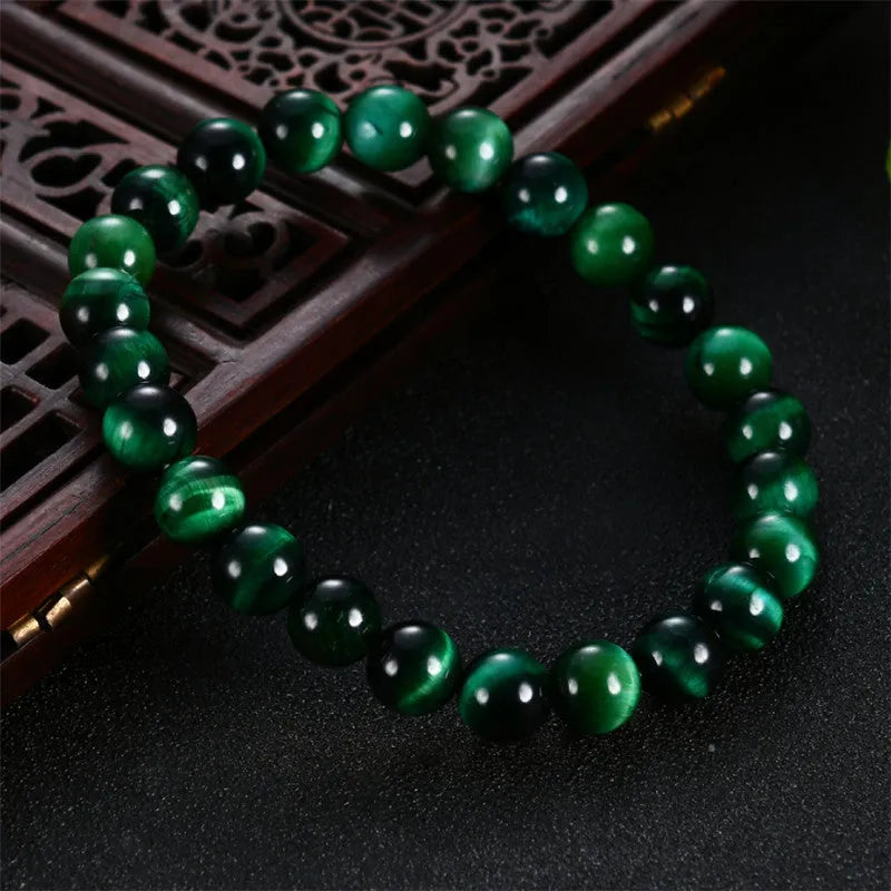 Green tiger eye stone bracelet with geometric beads in various sizes on wrist