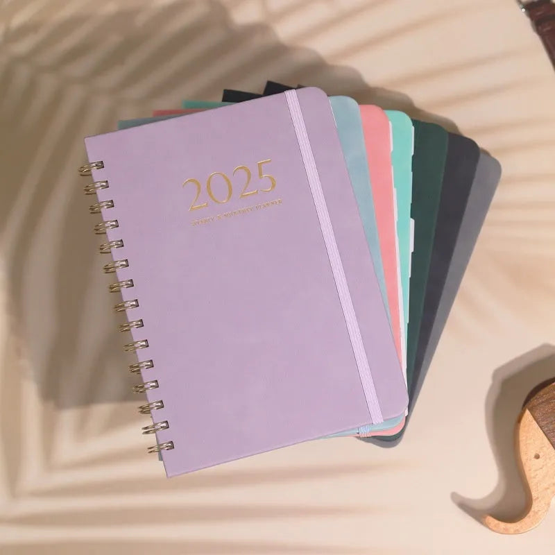 A5 leather notebook with metal coil binding showing multiple colour options including black, blue, brown, and green.