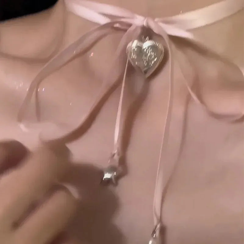 Women's alloy fashion necklace with ribbon design and a love pendant on a clavicle chain.