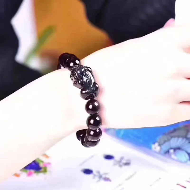 Natural ice colour eye obsidian crystal bracelet showing polished beads with characteristic banding patterns
