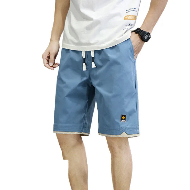 Loose fit casual shorts in green, shown on a model, featuring a straight leg and elasticated waist.