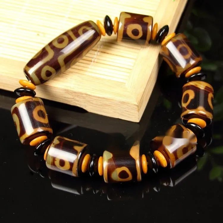 Distressed agate Tibet bead bracelet with three-eye motifs and multiple traditional bead styles on wrist