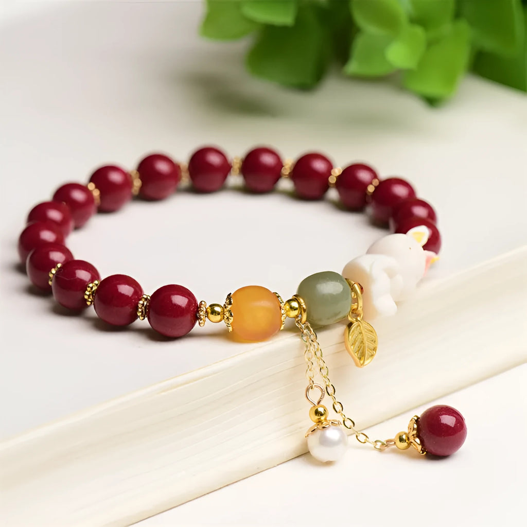 Women's natural cinnabar bracelet with a detailed rabbit pendant, shown in red.