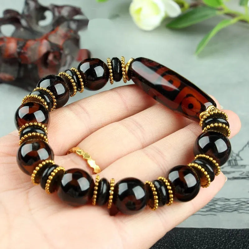 Distressed agate Tibet bead bracelet with three-eye motifs and multiple traditional bead styles on wrist
