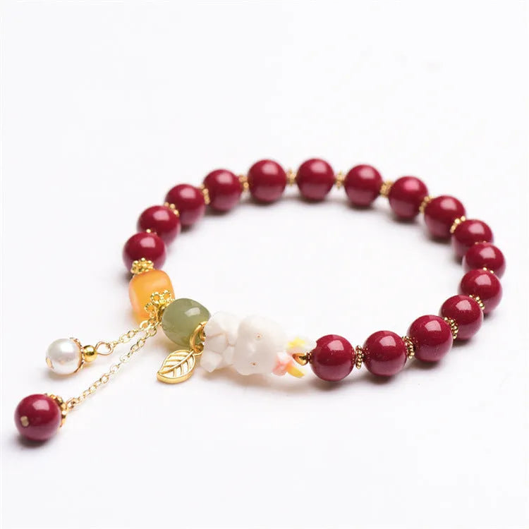 Women's natural cinnabar bracelet with a detailed rabbit pendant, shown in red.