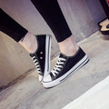 Women's solid colour canvas casual flat shoes on a plain background.