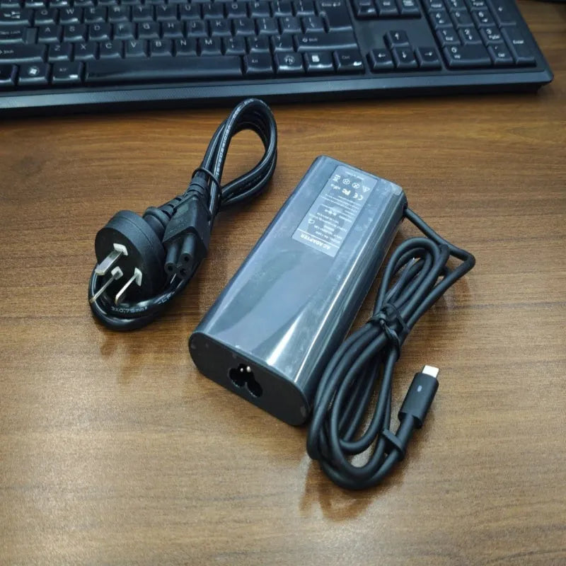 Black oval 65W Type-C laptop power adapter with international power cords