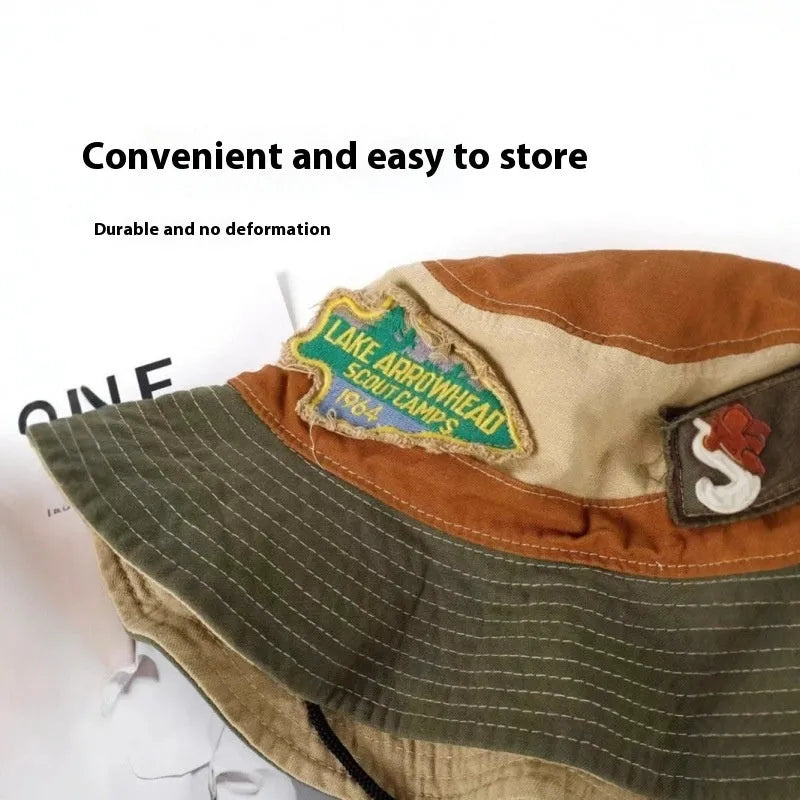 Army green cotton fisherman hat with patchwork design and flat top crown, folded to show storage feature