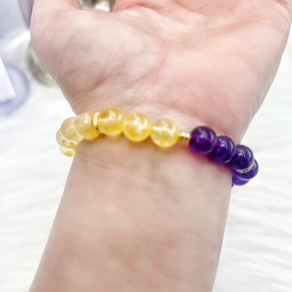 Handmade yellow and purple crystal bracelet for women on a wrist.