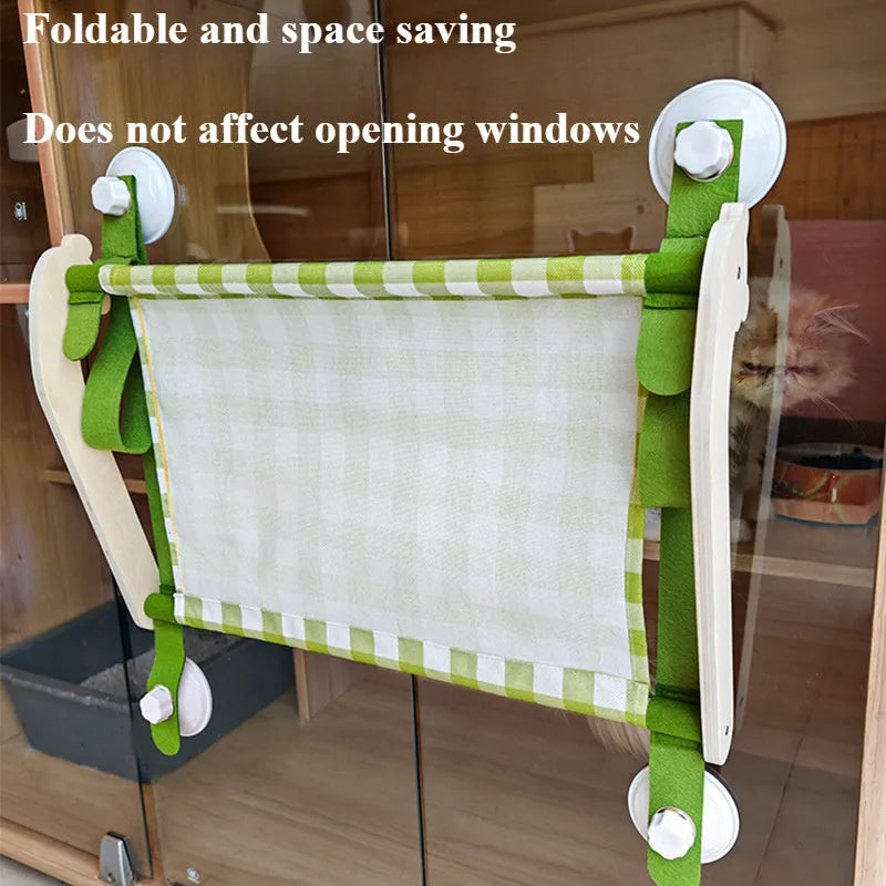 Pink wooden cat hammock bed with suction cups attached to a window, showing a cat lying on the linen mat.