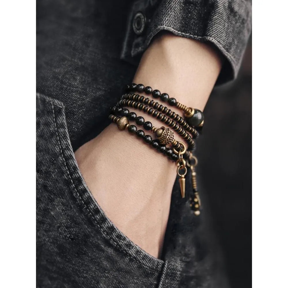 Close-up of a black multi-layered geometric bracelet made from beads, showing its textured construction.