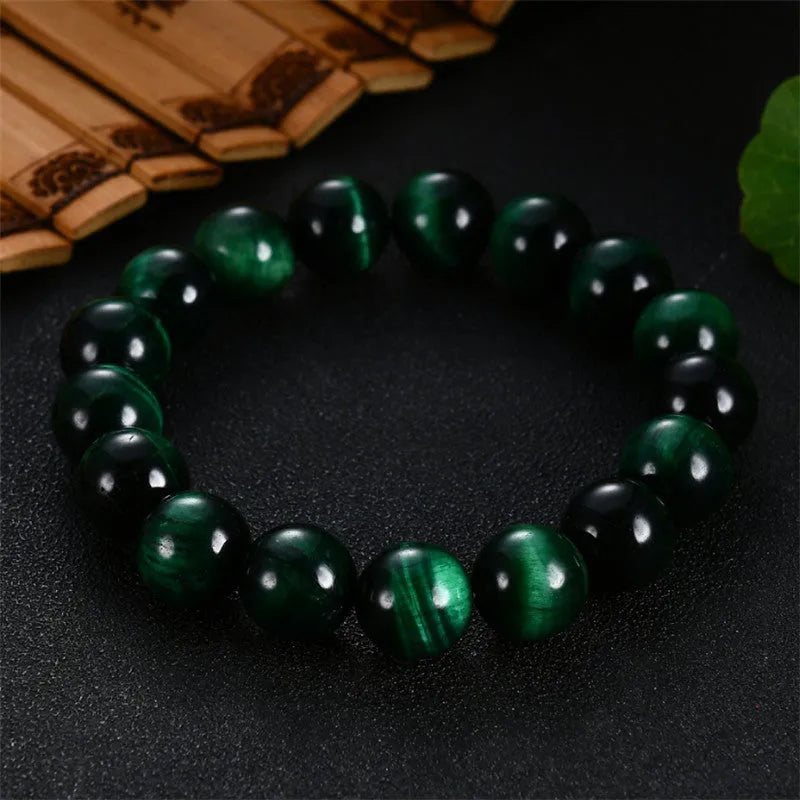 Green tiger eye stone bracelet with geometric beads in various sizes on wrist