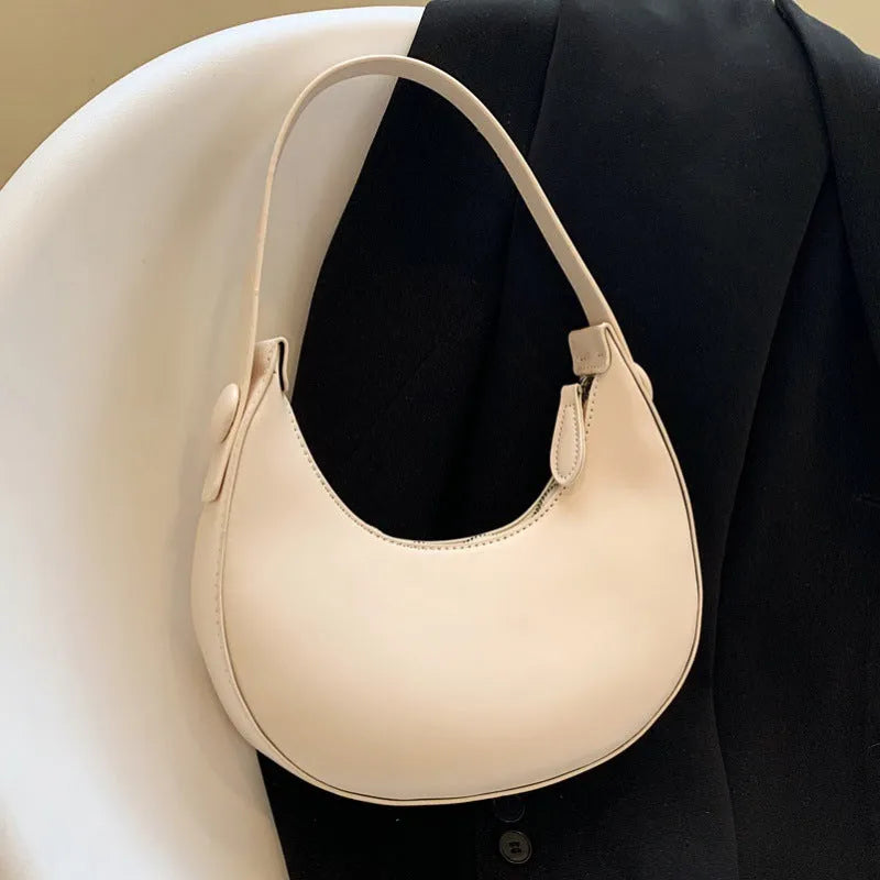 Women's retro-style PU shoulder bag in a dumpling shape, shown in cream yellow colour with a shoulder strap.