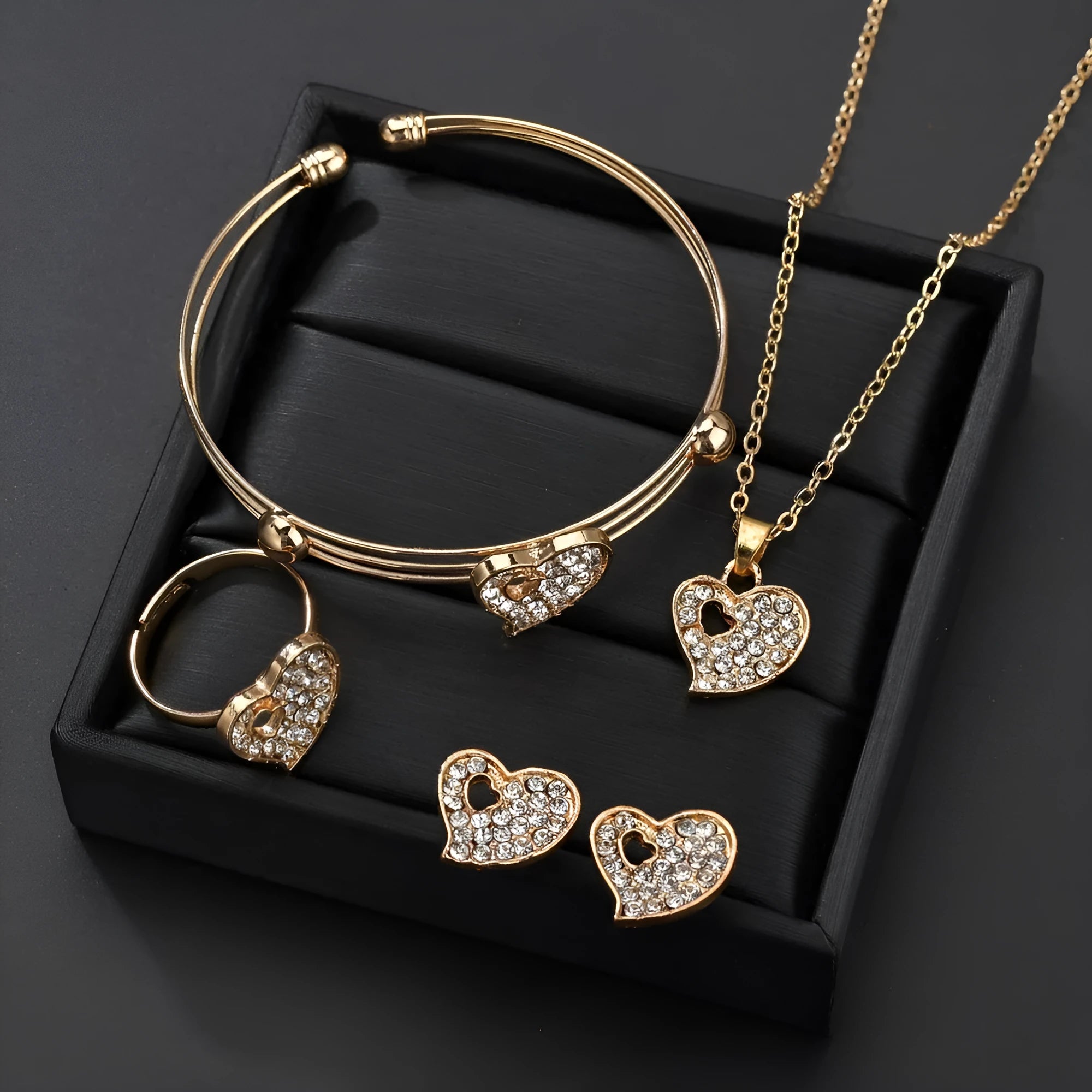 Gold-colour alloy jewellery set with earrings, pendant, and bracelet featuring love and bell patterns
