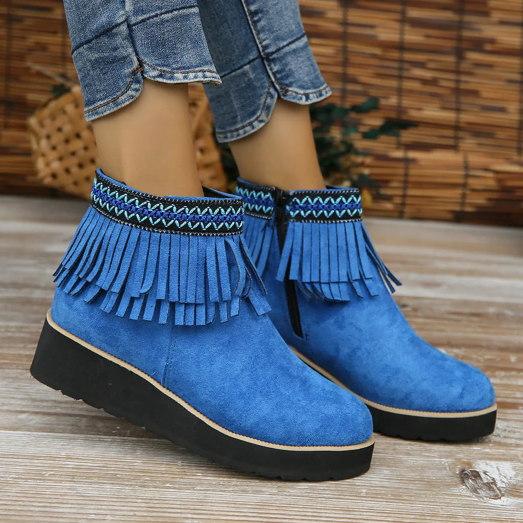 Women's black suede wedge ankle boots with a side zip and tassel detail on a thick rubber sole.