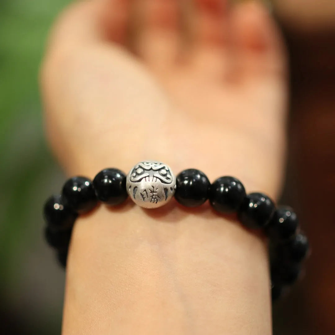Close-up of a women's bracelet with a 10mm black agate stone and Chinese-style sterling silver and alloy design.