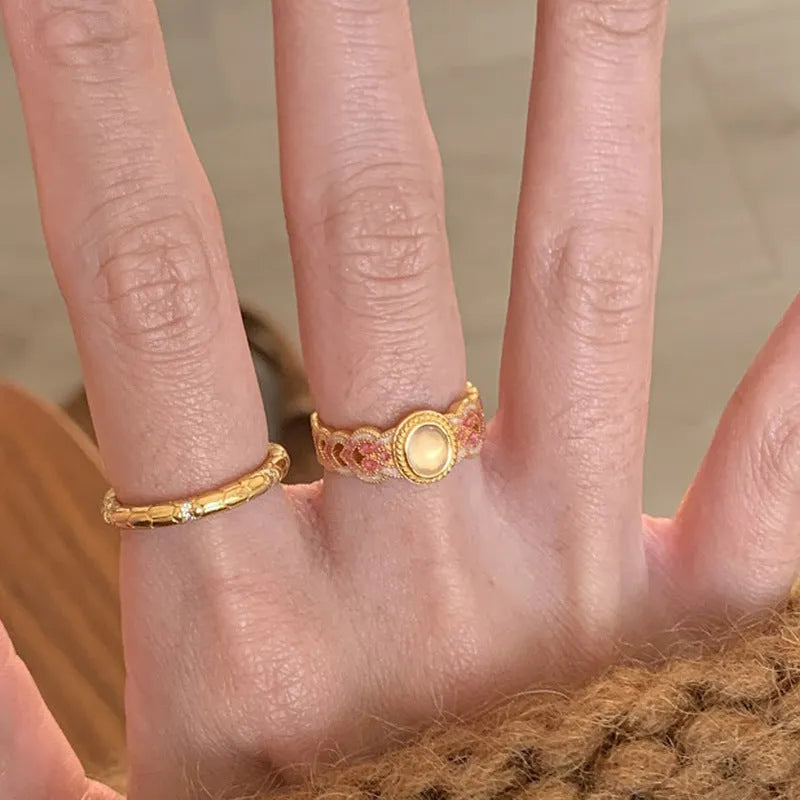 Geometric open ring for women with pink crystal enamel decoration on a gold-toned band.