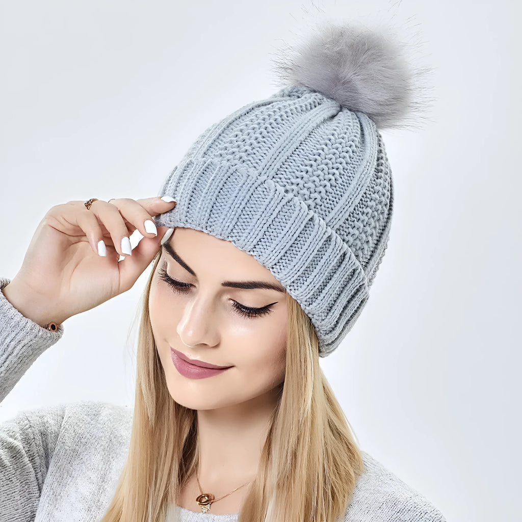 Women's knit beanie hat with faux fur pom pom and satin lining in wine red colour.