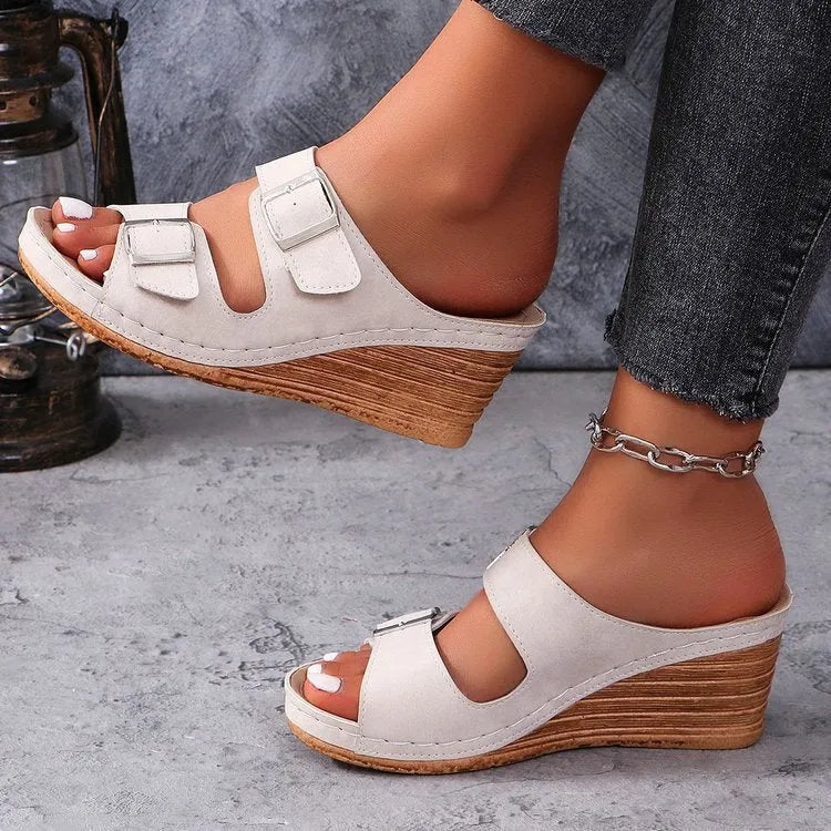 Women's creamy white beach slippers with a silver buckle on the strap