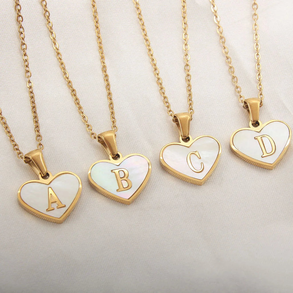 Gold plated heart pendant necklace with white shell centre and personalised letter engraving on adjustable chain