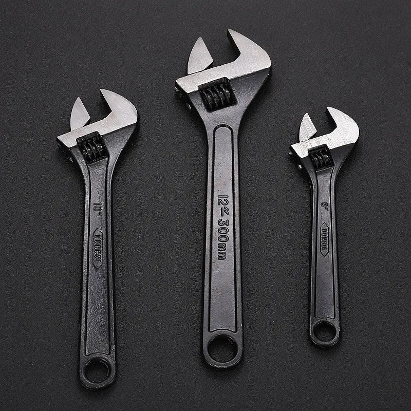 Stainless steel adjustable open-end wrench on a workbench
