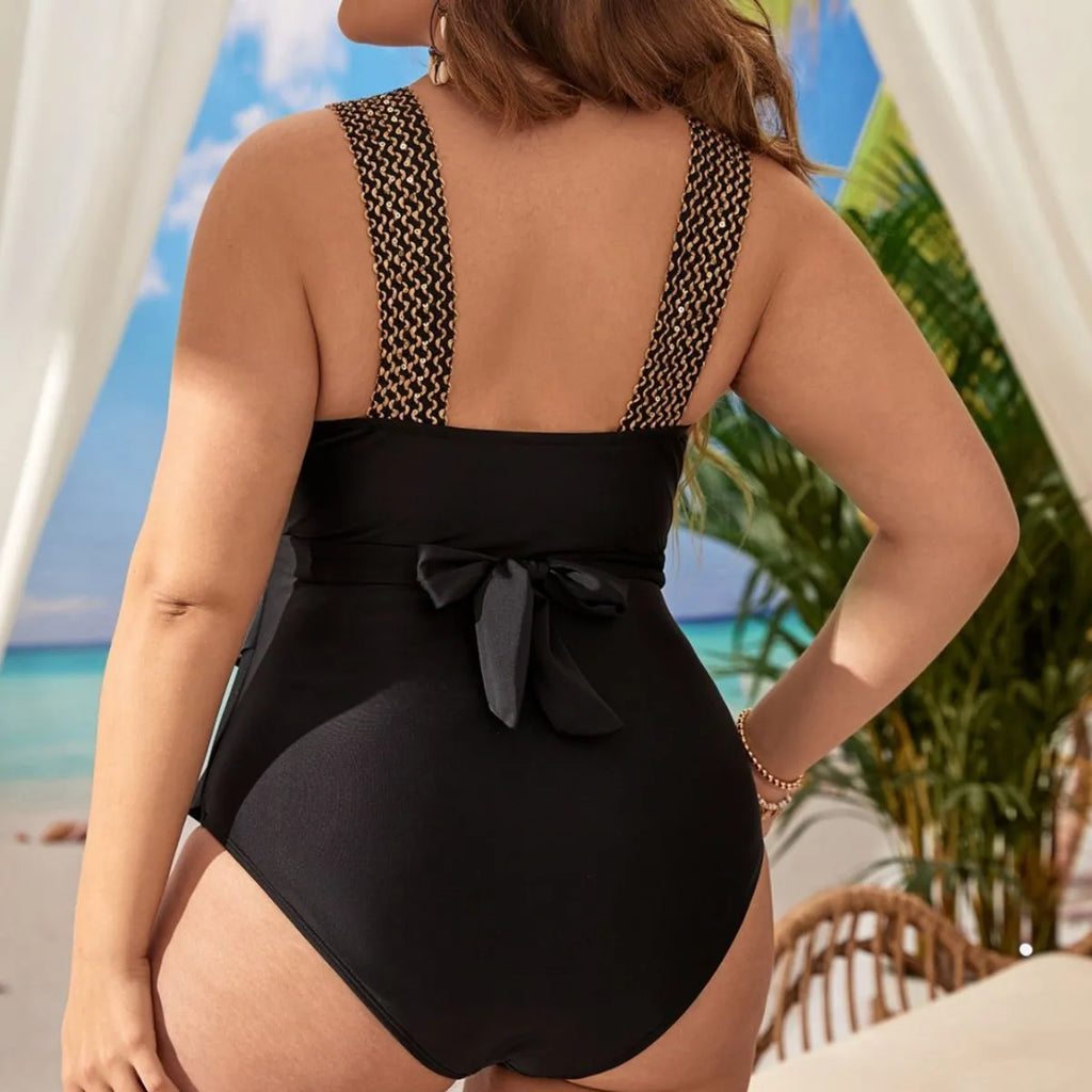 Women's black one-piece sleeveless swimsuit on a hanger, showing built-in chest pad detail.