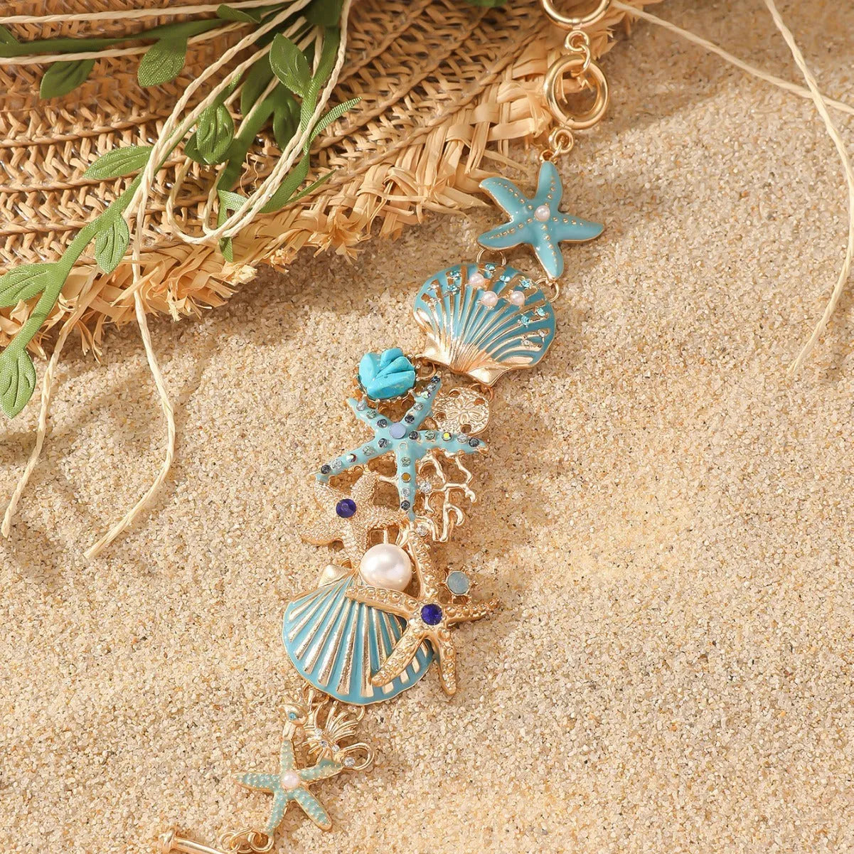 Starfish-shaped alloy bracelet with rhinestone anchor and shell details in turquoise, red, or blue.
