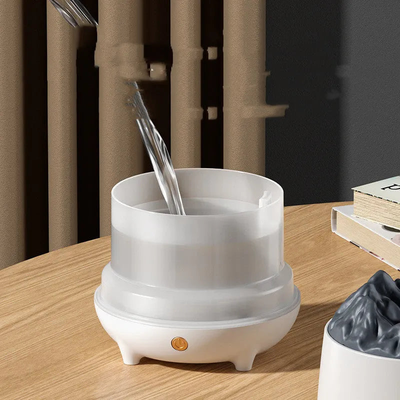 Black volcano-shaped ultrasonic humidifier and aroma diffuser with USB cable on a wooden table.