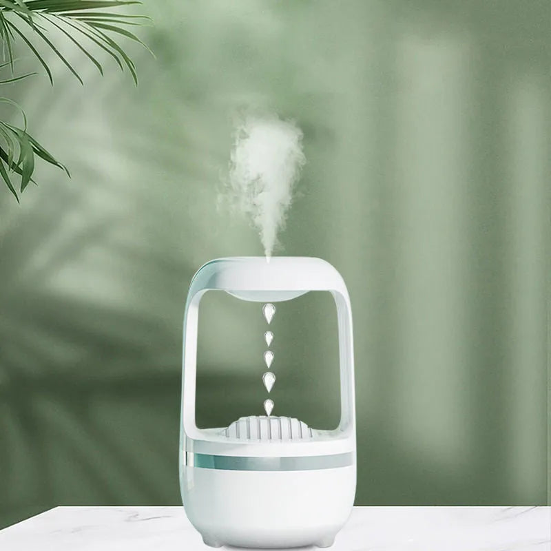White anti-gravity humidifier with floating water droplet on a desk next to a USB cable