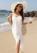 White women's crochet beach dress with suspenders and a bottom slit on a hanger.