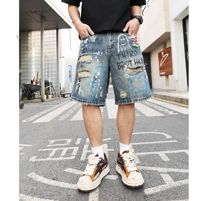 Blue men's ripped denim shorts with graffiti details and a straight leg opening.