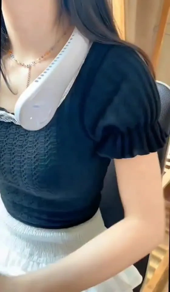 White bladeless neck fan being worn showing hands-free design and USB charging port
