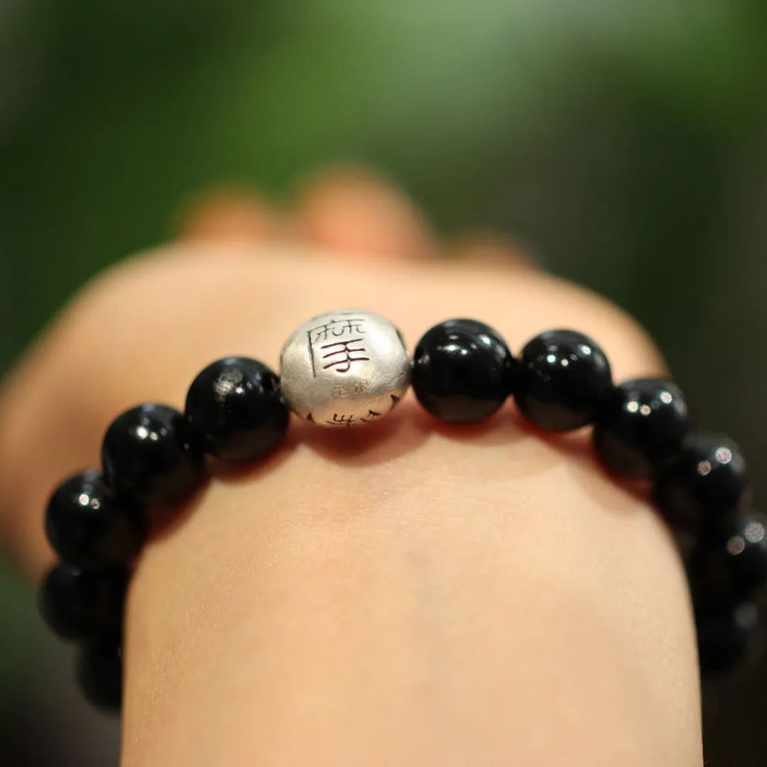 Close-up of a women's bracelet with a 10mm black agate stone and Chinese-style sterling silver and alloy design.