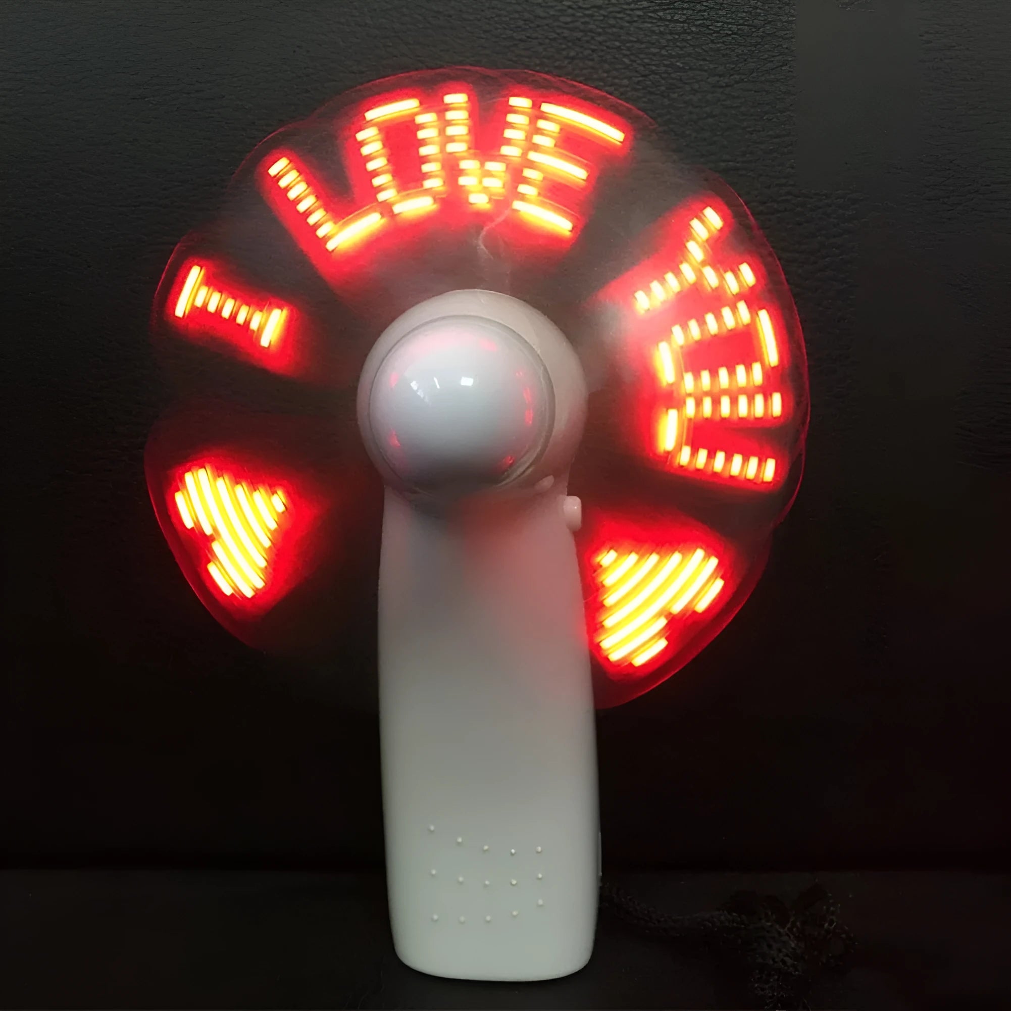 White handheld mini fan showing blue and red LED 'I love you' pattern flashing on front.