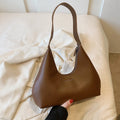 Brown retro PU leather shoulder handbag with a single strap and pillow-shaped design on a plain background.