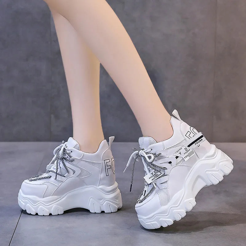 Women's white low-top platform tennis shoes with mesh upper and cross-strap detail on a rubber sole.