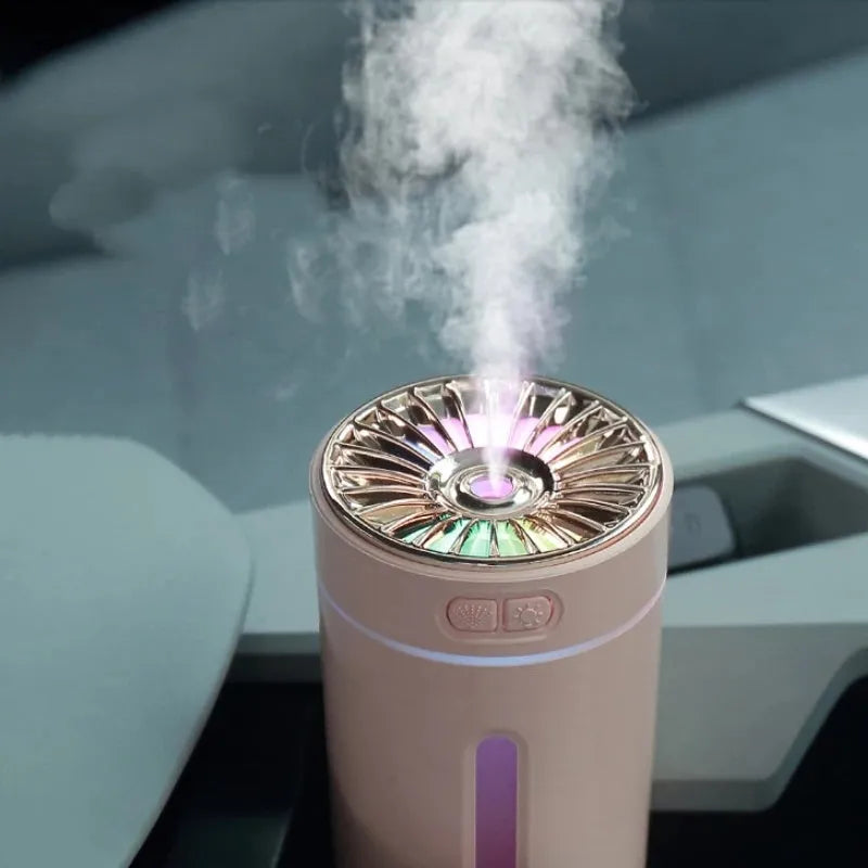 Black portable wireless ultrasonic humidifier with colourful LED lights on a car cup holder.