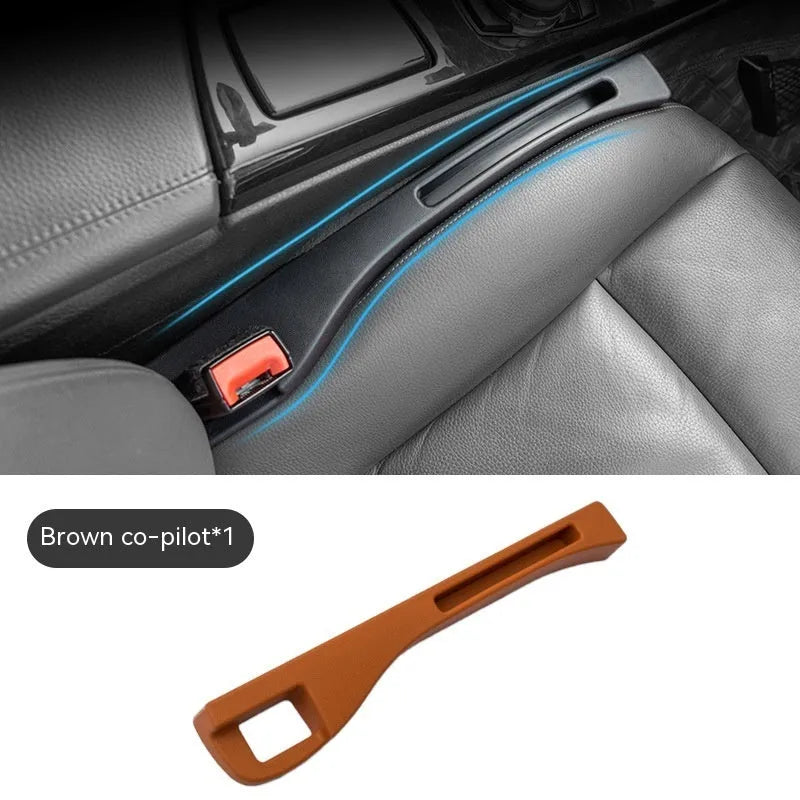 Black plastic car seat gap storage box with handle positioned between vehicle seats