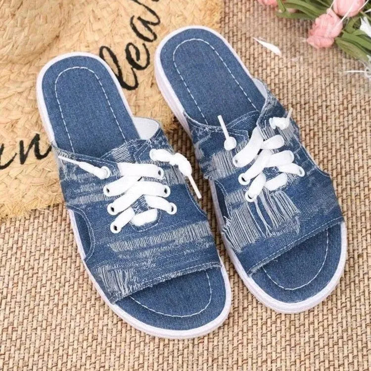 Blue Roman-style women's flat canvas slippers with cloth upper and rubber sole.