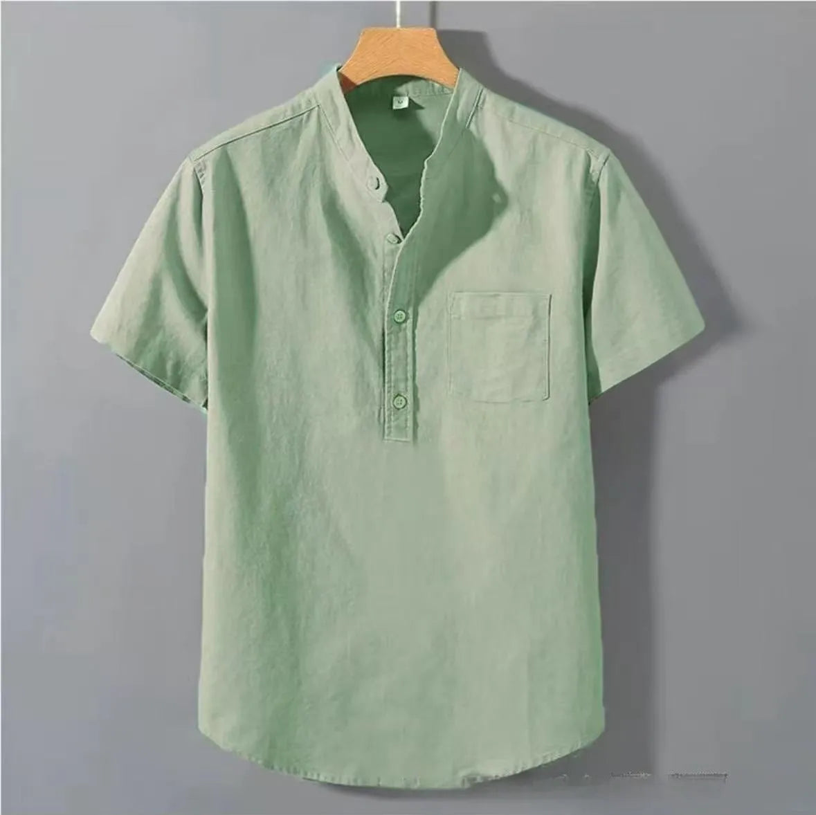 Men's loose-fit solid colour linen shirt with a stand collar and short sleeves on a hanger.