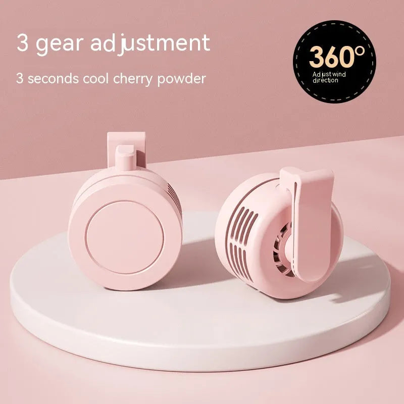 Green wrist-worn personal fan with USB charging port, LED light, and adjustable strap.