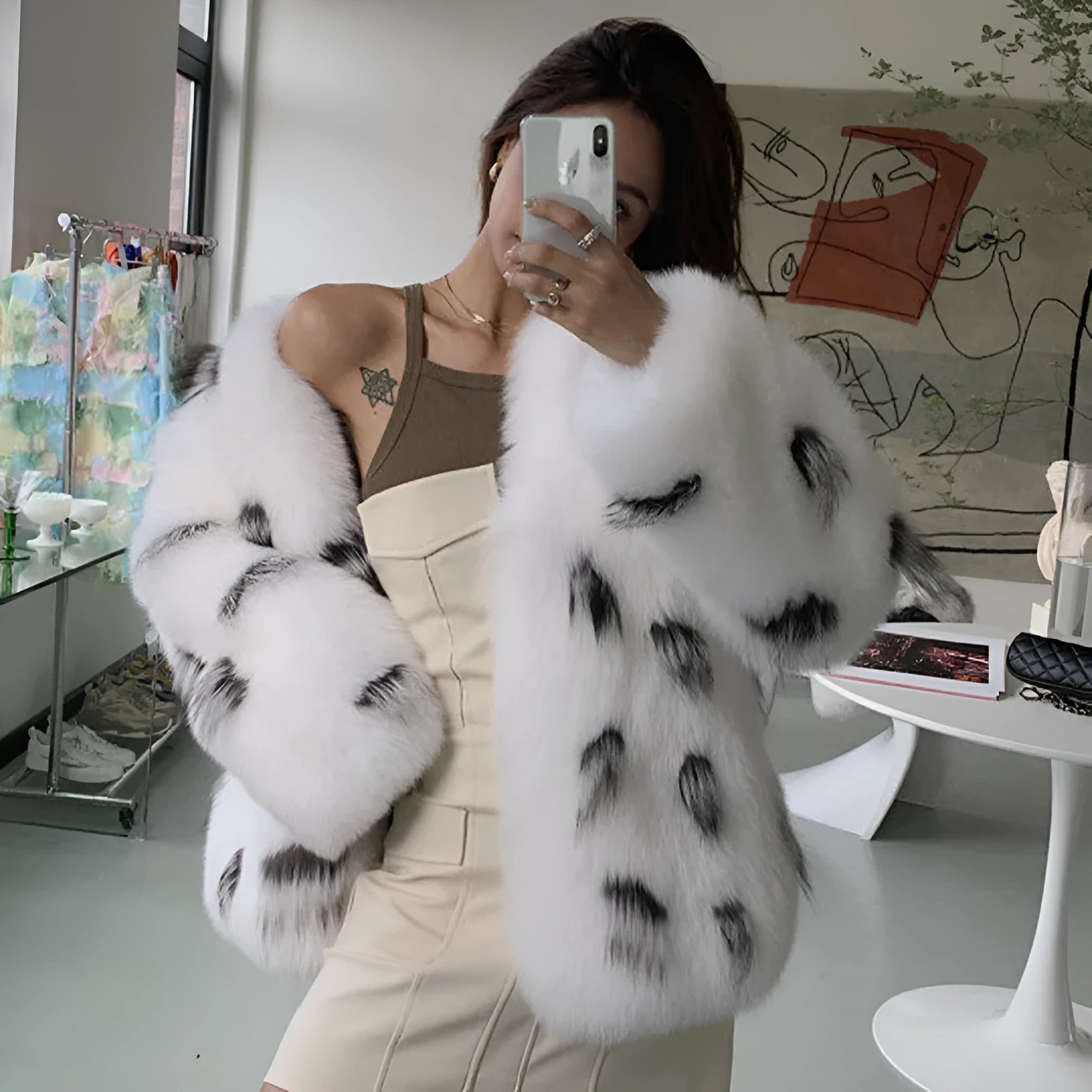Women's short black and white faux raccoon fur coat in Korean street style, shown on a hanger.