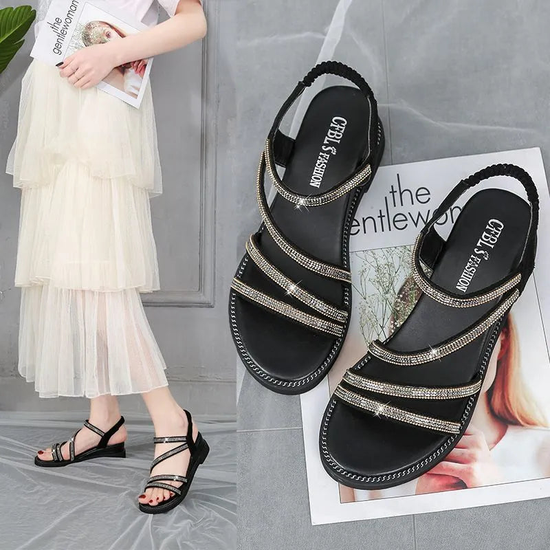 Women's silver flat sandals with rhinestone decoration and elastic band, showing the round toe and rubber sole.