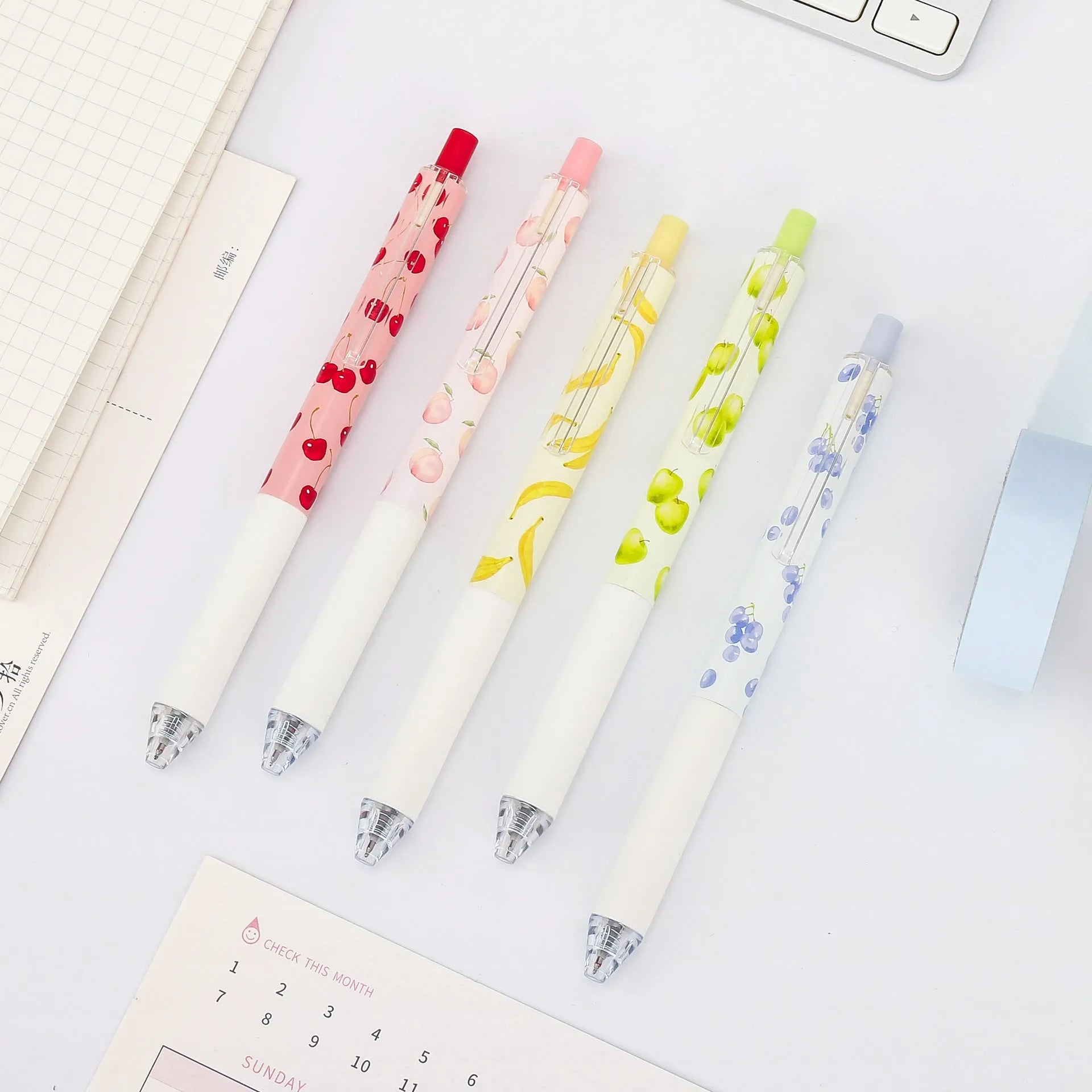 Three scented fruit pens with 0.5mm black ink and press mechanism on white background