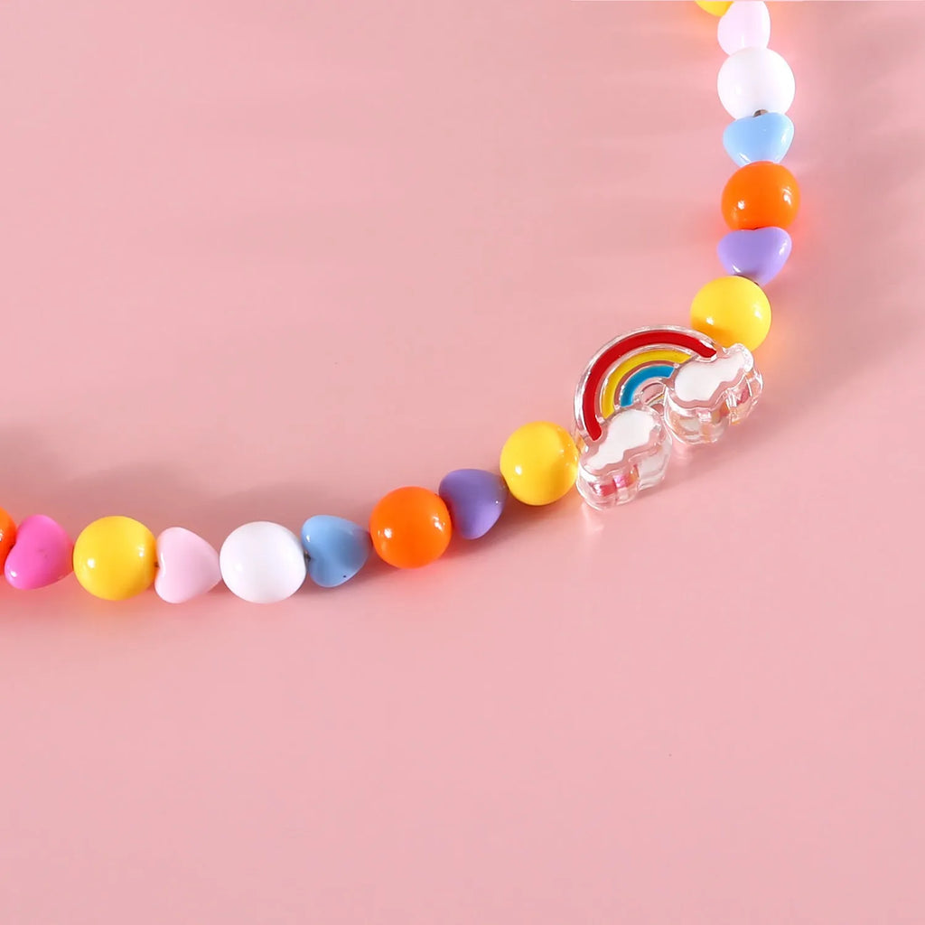 Colourful plastic pearl bead cat collar with a small flower charm on a white background.