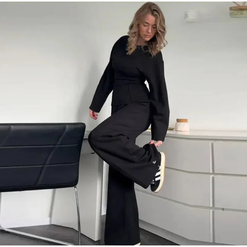 Women's black polar fleece suit set with long sleeve O-neck top and wide leg trousers.