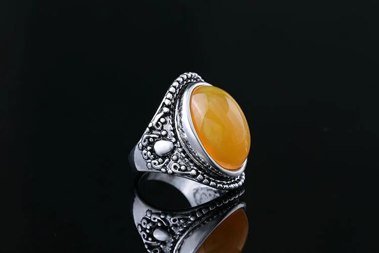 Geometric fluorescent beeswax alloy ring in antique silver amber colour on a grey background.