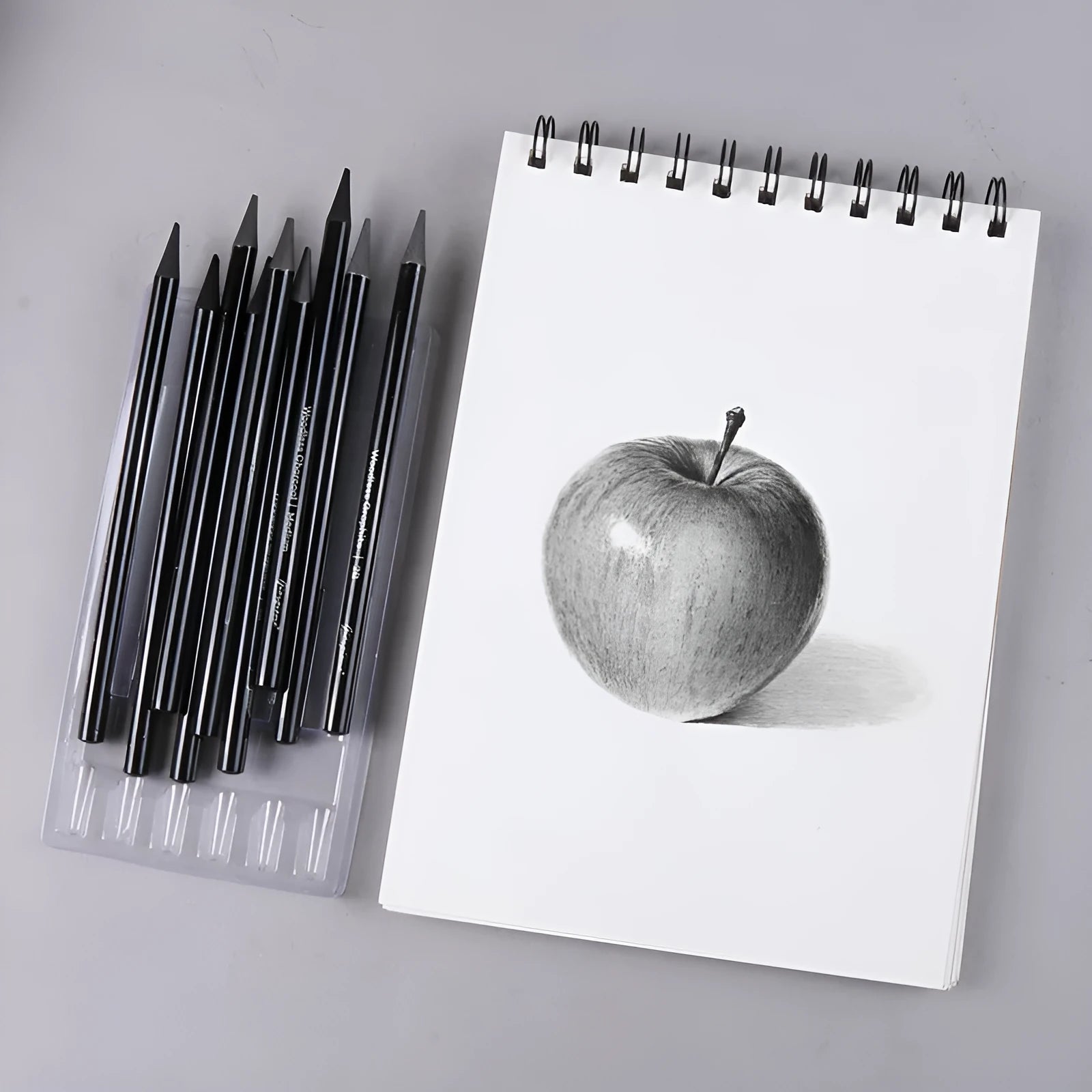 Set of nine wooden drawing pencils on a suction card, containing six graphite and three carbonized pencils for artist sketching.